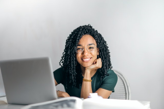 woman sitting at desk working on computer smiling