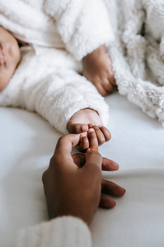 mother's hand holding baby's hand